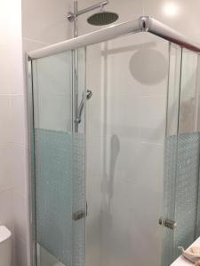 um chuveiro com porta de vidro em um banheiro em Tossan House in Vilamoura Downtown em Quarteira