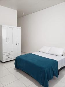 a white bedroom with a bed and a white cabinet at Amigos da Praia in Fortaleza