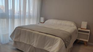 a bedroom with a large bed with white sheets at Departamento centro mdp calle belgrano in Mar del Plata