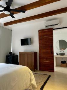 图卢姆BT Rooms Tulum的一间卧室，墙上有一张床和一台电视