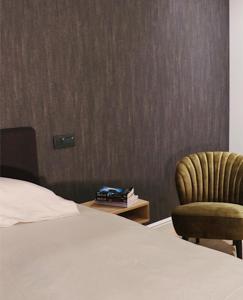ein Bett und ein Stuhl in einem Hotelzimmer in der Unterkunft B&B Punto Vélo in Zutendaal