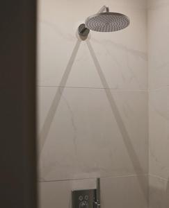eine Dusche mit Duschkopf an der Wand in der Unterkunft B&B Punto Vélo in Zutendaal