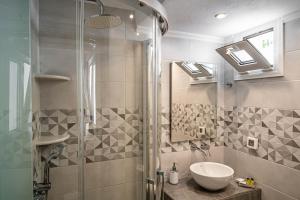 ein Badezimmer mit Waschbecken und Dusche in der Unterkunft Galatia Villas in Fira