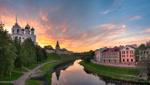 a view of a river in a city with buildings at Golden Embankment in Pskov