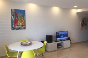 a room with a table and a tv and a table and chairs at Marina Mar in Vilamoura downtown in Quarteira