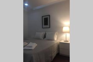 a bedroom with a bed with a lamp on a night stand at Marina Mar in Vilamoura downtown in Quarteira