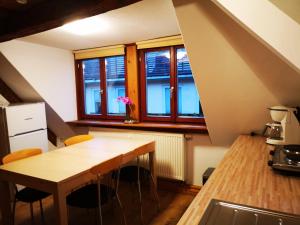 a kitchen with a wooden table and some windows at charmante Pension zentral in Reutlingen