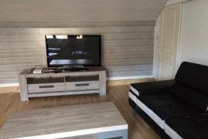 a living room with a flat screen tv on a table at Longère entre terre et mer in Marquise
