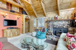 a living room with a stone fireplace and a tv at Serene Escape in Soda Springs