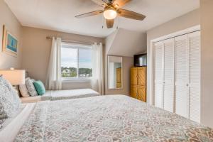 a bedroom with a large bed with a ceiling fan at Tybee Lights in Tybee Island