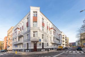 a white building on the corner of a street at MARGI Martini BIG BEAUTI STUDIO in Szczecin