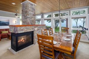 a dining room with a table and a fireplace at Larsmont Cottages in Two Harbors