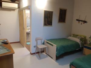 - une chambre avec un lit, une table et un bureau dans l'établissement Al Fienile, à Orzano