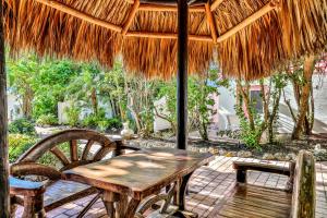 un tavolo in legno con sedie sotto un ombrellone di paglia di Sunrise Garden Resort ad Anna Maria