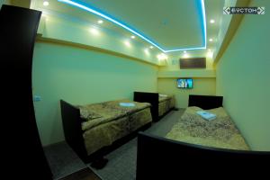 um quarto com duas camas e uma luz azul em Hostel Buston em Chkalovsk