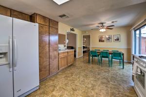 a kitchen with a white refrigerator and green chairs at Updated Family Home - 2 Blocks to Colorado River! in Bullhead City