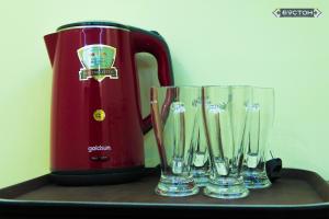 three empty wine glasses next to a red blender at Hostel Buston in Chkalovsk