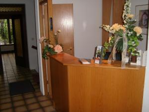 a reception desk with flowers on top of it at Zum Bergischen Hof in Dormagen
