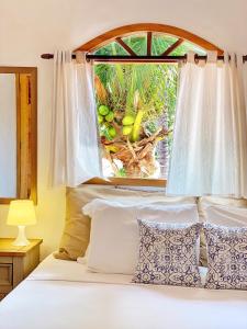 a bedroom with a bed with a window at Villa Medina Jeri in Jericoacoara