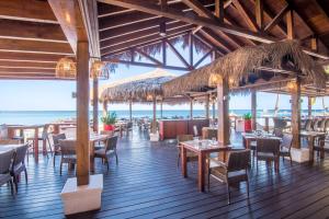 a restaurant on the beach with tables and chairs at Holiday Inn Resort Aruba - Beach Resort & Casino by IHG in Palm-Eagle Beach