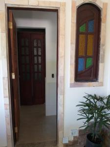 a hallway with a door and a window at Recanto Suítes in Araruama