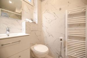 een witte badkamer met een toilet en een wastafel bij Cosy home in Paris Center - With AC in Parijs