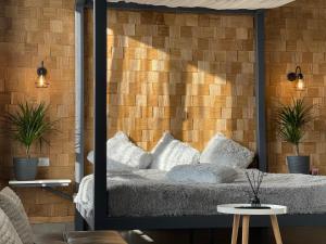 a bedroom with a bed and a brick wall at Kalinova Sloboda Apartment in Ivano-Frankivsʼk