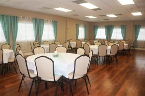 una sala de conferencias con mesas y sillas blancas en El Coronado Resort, en Wildwood Crest