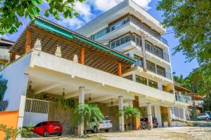 um edifício com um carro vermelho estacionado em frente dele em Hospedaria Vitória Mar em Ubatuba