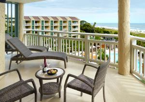 uma varanda com cadeiras e uma mesa e o oceano em Omni Hilton Head Oceanfront Resort em Hilton Head Island