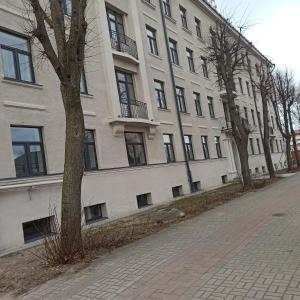 a large white building with a tree in front of it at Allegro in Liepāja