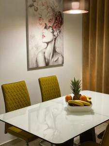 a white table with a bowl of fruit on it at Luxury family apartment Tomi in Slavonski Brod