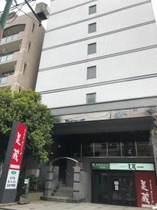 un bâtiment avec un panneau devant lui dans l'établissement Hotel Route-Inn Kitamatsudo Ekimae, à Matsudo