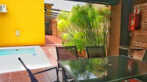 una mesa de cristal y sillas en una habitación con piscina en Loft Andino I - Comfort moderno a 5' del centro en Salta