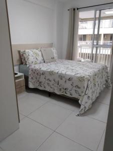 ein Schlafzimmer mit einem Bett und einem großen Fenster in der Unterkunft Apartamento para família moderno e prático próximo a belas praias in Cabo Frio