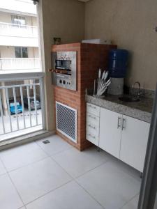 eine Küche mit einem Herd und einer Theke mit einem Fenster in der Unterkunft Apartamento para família moderno e prático próximo a belas praias in Cabo Frio