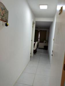 einen Flur eines Zimmers mit weißem Fliesenboden in der Unterkunft Apartamento para família moderno e prático próximo a belas praias in Cabo Frio + 11 Fotos