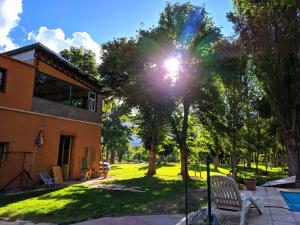 a sun shines through a tree in a yard at Hosteria Uspallata in Uspallata