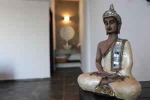a statue of a man sitting on a table at Hotel Lunazul In Costa Esmeralda in La Vigueta