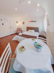 ein weißes Zimmer mit einem Tisch und einem Bett in der Unterkunft Apartment Ruska 12 in Lwiw