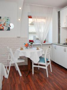 eine Küche mit einem Tisch und 2 Stühlen sowie eine Küche mit einem Tisch und Stühlen in der Unterkunft Apartment Ruska 12 in Lwiw