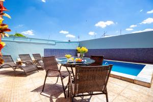 a patio with a table and chairs next to a pool at Hotel Dan Inn Barretos in Barretos