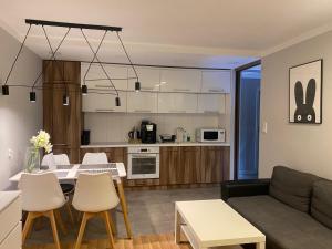 a living room and kitchen with a table and a couch at Family & Business Elegant Apartments Rynek Centrum Downtown - 2 Bedroom, Balcony, Parking in Kielce