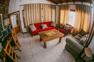 sala de estar con sofá rojo y mesa en Hotel Tierra Colorada en Puerto Iguazú