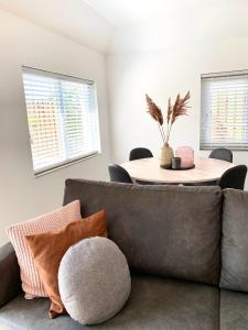 uma sala de estar com um sofá e uma mesa em Liv Residence Holiday Home with Sauna & Fireplace em Ermelo