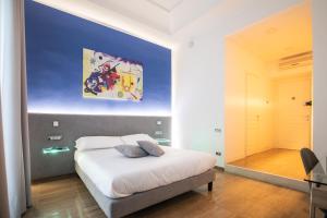 una camera da letto con un letto e un dipinto sul muro di Sanfelice 33 Luxury Suites a Napoli