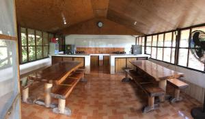 duża kuchnia z drewnianymi stołami w domu w obiekcie The Pelicans Resort w mieście Batangas