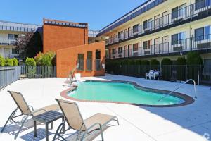 a swimming pool with chairs and a building at Olympic Inn & Suites Port Angeles in Port Angeles