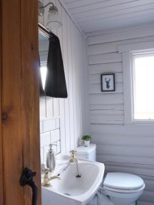 Baño blanco con aseo y lavamanos en Hillside Log cabin, Ardoch Lodge, Strathyre, en Strathyre
