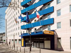 パリにあるHotelF1 Paris Saint Ouen Marché Aux Pucesの旗の付いた建物の正面